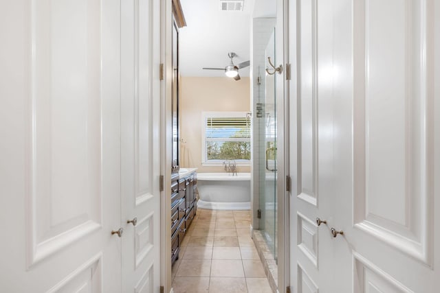 full bath featuring visible vents, tile patterned flooring, a freestanding tub, and vanity