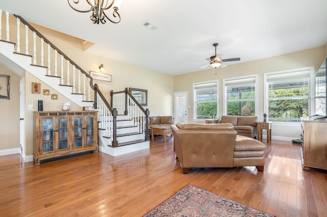 living area featuring hardwood / wood-style flooring, baseboards, stairs, and visible vents