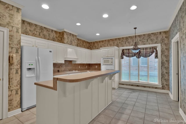 kitchen with white appliances, light countertops, white cabinetry, light tile patterned floors, and custom range hood