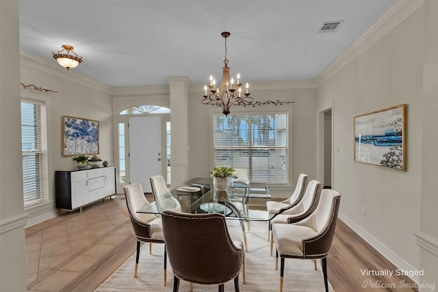 dining area with a notable chandelier, visible vents, ornamental molding, and baseboards