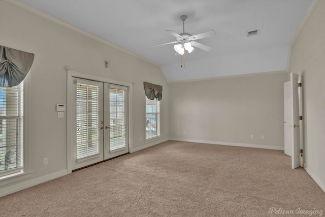 carpeted empty room with vaulted ceiling, visible vents, ornamental molding, and french doors