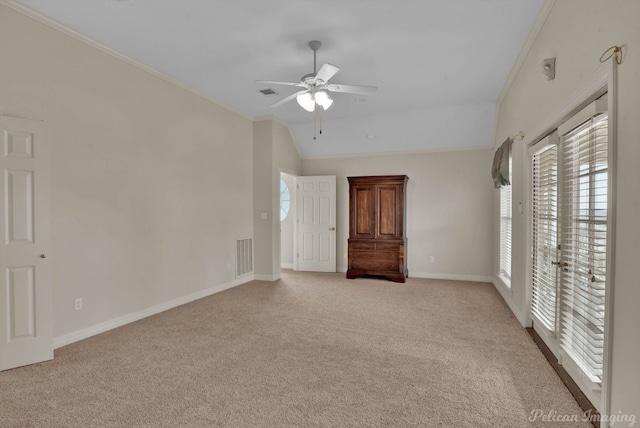 interior space with light colored carpet, visible vents, access to exterior, vaulted ceiling, and crown molding