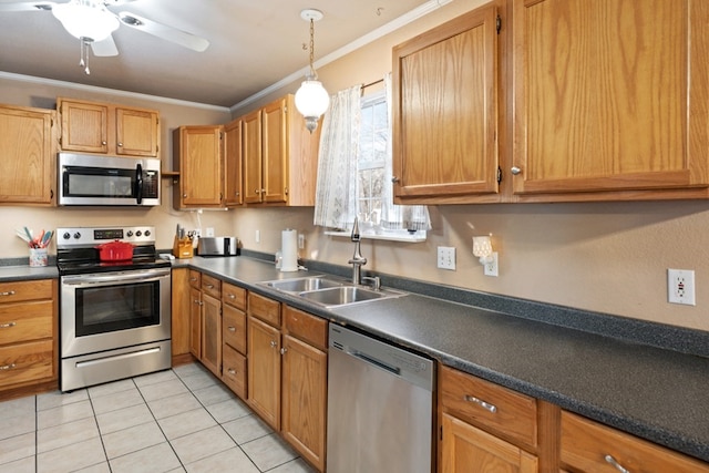 kitchen with dark countertops, ornamental molding, stainless steel appliances, and a sink