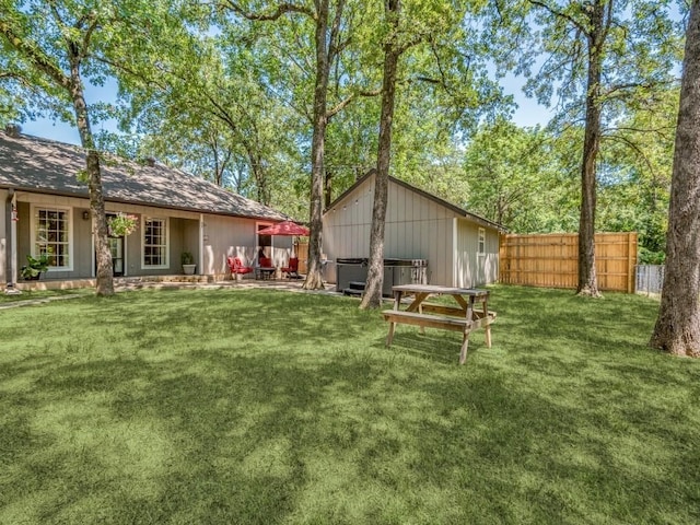 rear view of house with fence and a lawn