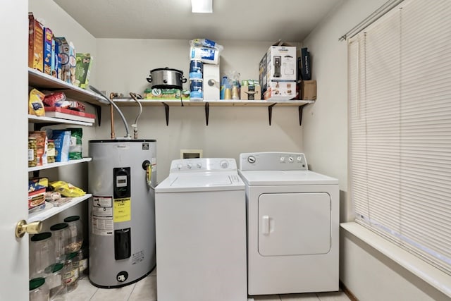 laundry area with laundry area, washing machine and dryer, light tile patterned flooring, and electric water heater