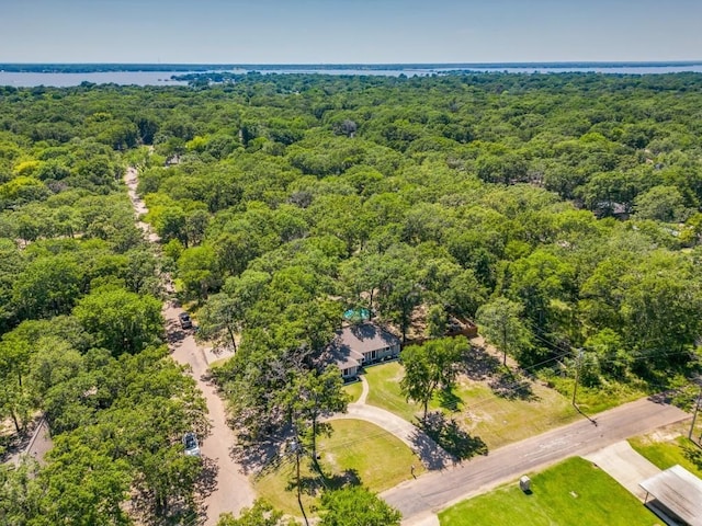 birds eye view of property featuring a water view and a wooded view