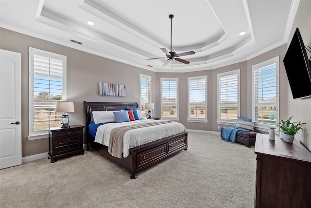 bedroom featuring a tray ceiling, visible vents, carpet flooring, and multiple windows