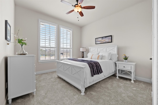 bedroom with ceiling fan, baseboards, and light colored carpet