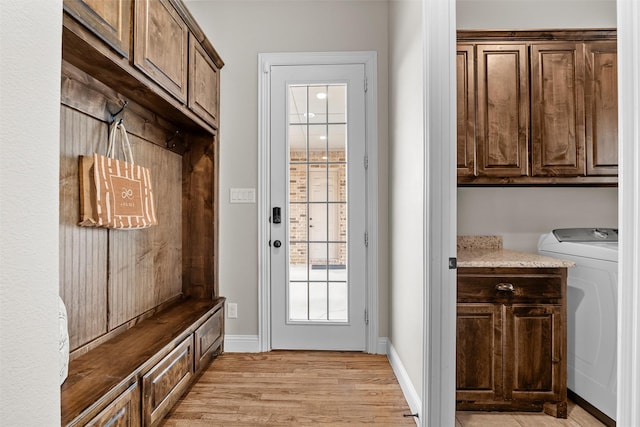 mudroom with light wood-type flooring, washer / dryer, and baseboards