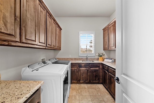 laundry area with cabinet space, a sink, washer and clothes dryer, and light tile patterned floors