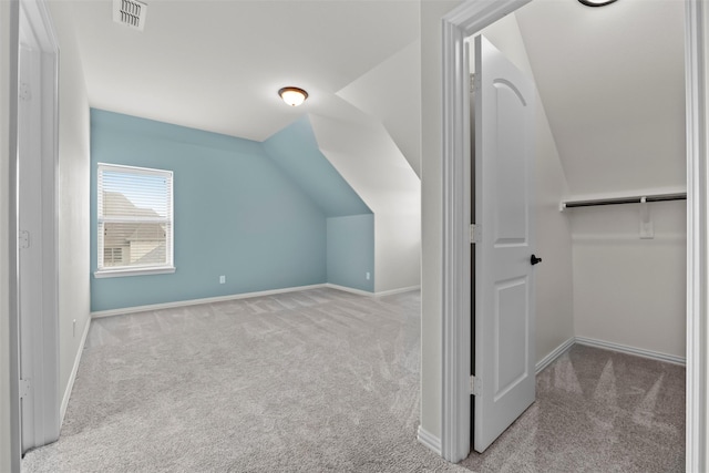 additional living space with lofted ceiling, carpet flooring, visible vents, and baseboards