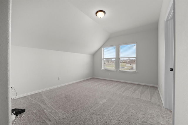 bonus room with lofted ceiling, baseboards, and carpet flooring