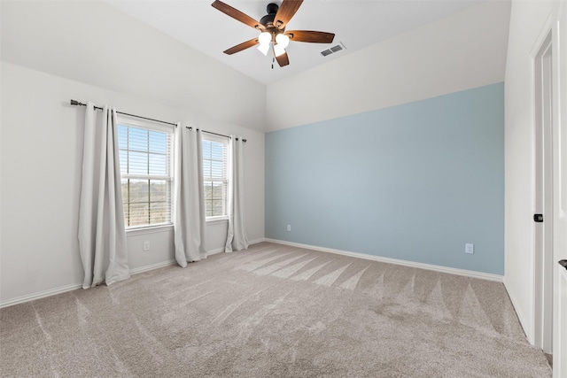 carpeted empty room featuring a ceiling fan, visible vents, vaulted ceiling, and baseboards