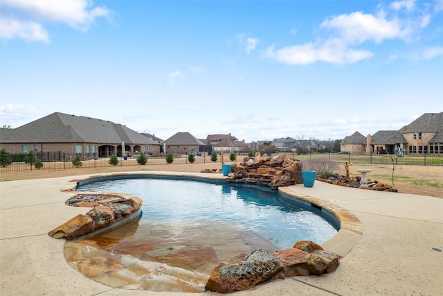 view of swimming pool featuring a fenced in pool, a residential view, fence, and a patio