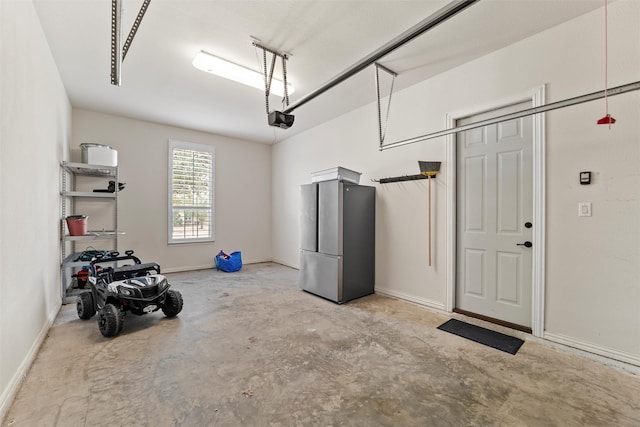 garage featuring baseboards, freestanding refrigerator, and a garage door opener