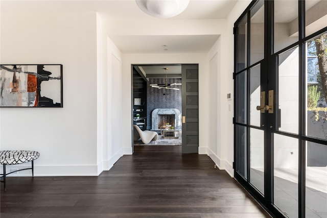 hall with baseboards, wood finished floors, and french doors