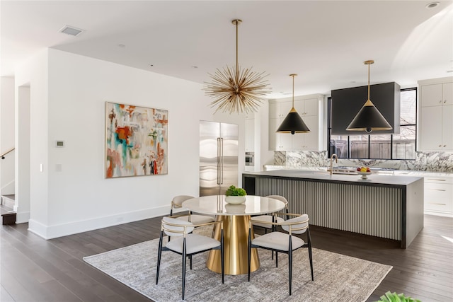 dining area featuring dark wood-type flooring, stairway, visible vents, and baseboards