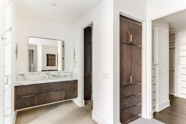 bathroom featuring a walk in closet and vanity