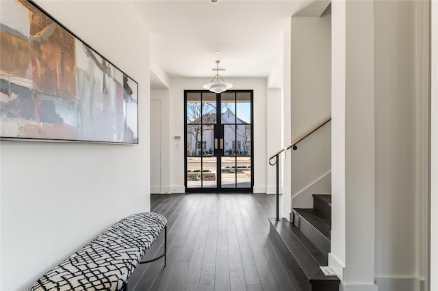 foyer entrance with baseboards, stairway, and dark wood finished floors