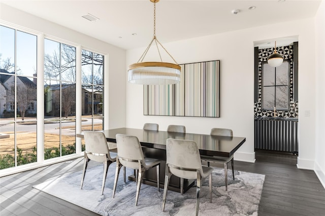 dining area featuring dark wood-type flooring, a wealth of natural light, and baseboards