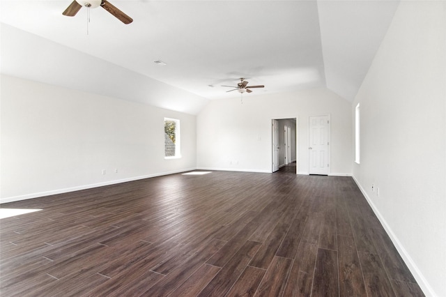 empty room featuring dark wood-type flooring, vaulted ceiling, baseboards, and ceiling fan