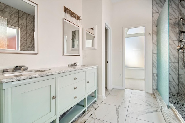 full bath with a sink, baseboards, marble finish floor, double vanity, and a stall shower