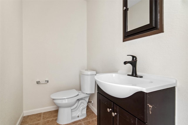 half bath featuring tile patterned flooring, baseboards, vanity, and toilet