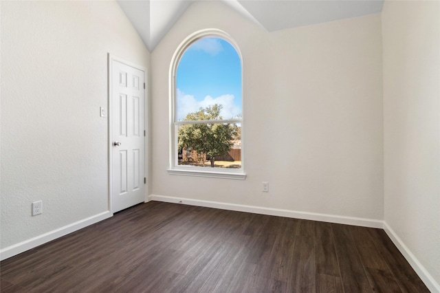 unfurnished room with lofted ceiling, dark wood-type flooring, and baseboards