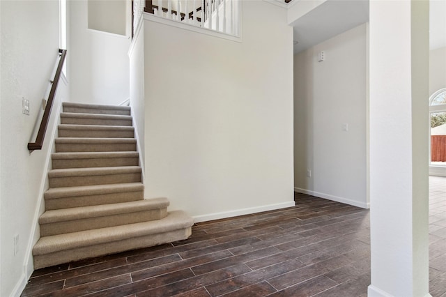 staircase with wood finished floors and baseboards