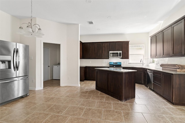 kitchen with a sink, light stone countertops, appliances with stainless steel finishes, and dark brown cabinets