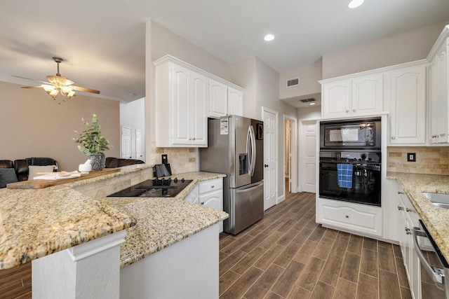 kitchen featuring visible vents, light stone counters, a peninsula, wood tiled floor, and black appliances