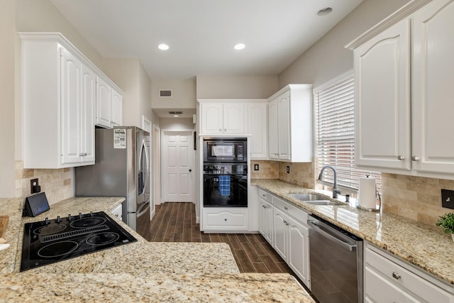 kitchen with a sink, visible vents, white cabinets, wood tiled floor, and black appliances