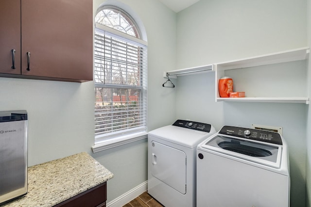 washroom with dark wood-type flooring, baseboards, cabinet space, and washing machine and clothes dryer