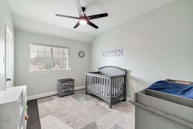 carpeted bedroom featuring a ceiling fan, vaulted ceiling, and baseboards