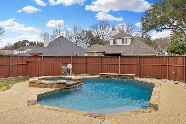 view of pool featuring a fenced backyard and a pool with connected hot tub