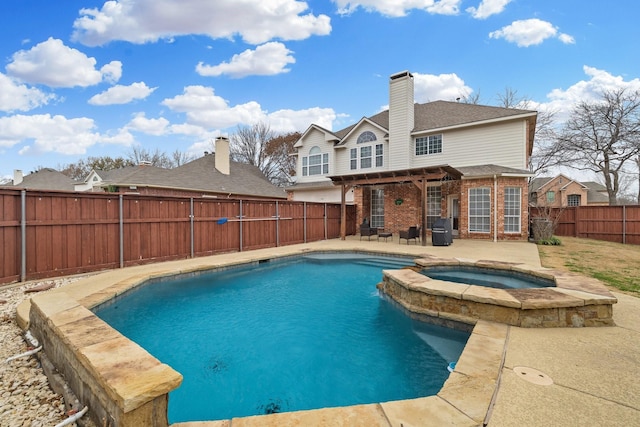 view of pool with a patio area, a fenced backyard, and a pool with connected hot tub