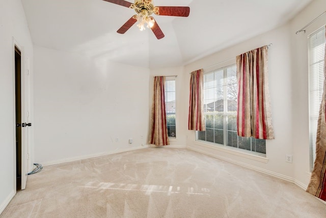 carpeted empty room featuring lofted ceiling, a ceiling fan, and baseboards