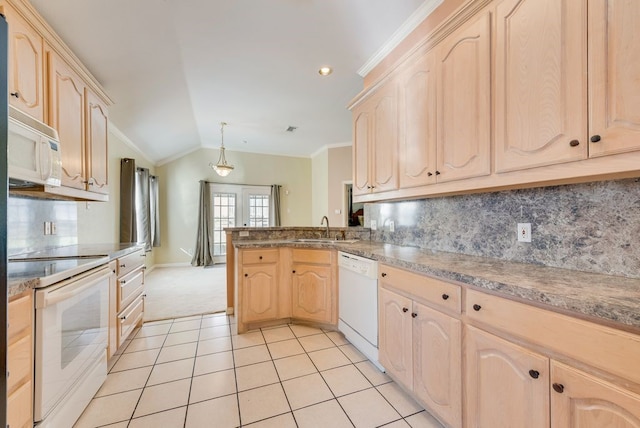 kitchen with white appliances, light brown cabinets, and a peninsula