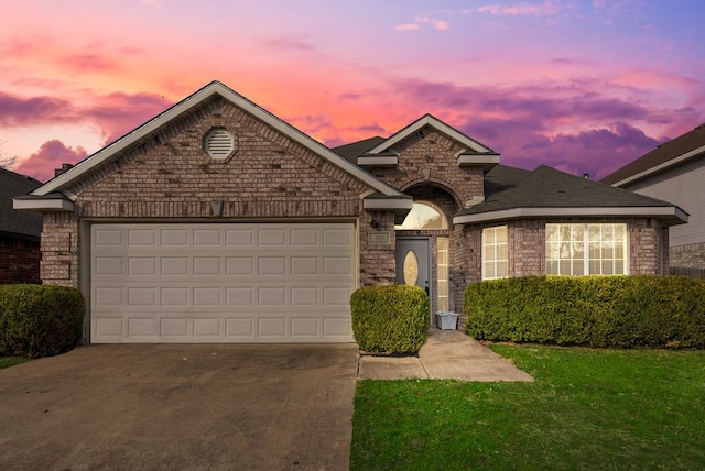 single story home with concrete driveway, brick siding, a yard, and an attached garage