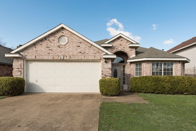 ranch-style house with brick siding, roof with shingles, concrete driveway, a garage, and a front lawn