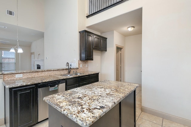 kitchen featuring visible vents, backsplash, a sink, light stone countertops, and stainless steel dishwasher