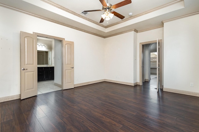 spare room featuring crown molding, a raised ceiling, and wood finished floors