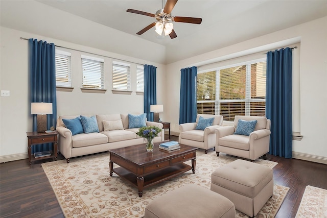 living room featuring vaulted ceiling, ceiling fan, baseboards, and wood finished floors