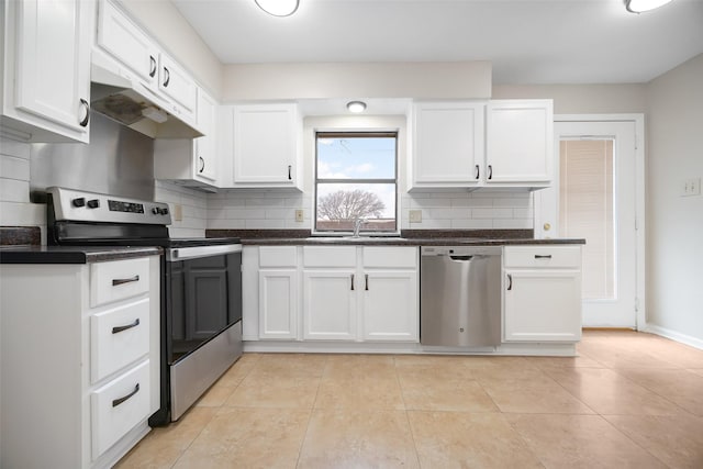 kitchen with appliances with stainless steel finishes, a sink, white cabinetry, and decorative backsplash