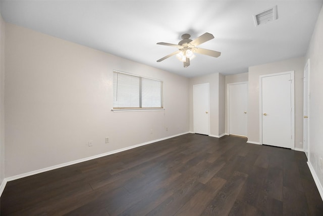 unfurnished bedroom with baseboards, visible vents, ceiling fan, and dark wood-style flooring