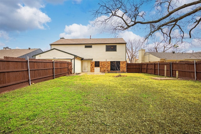 back of house featuring a fenced backyard, a lawn, and brick siding