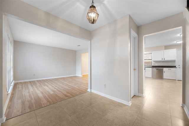 empty room with light tile patterned floors and baseboards