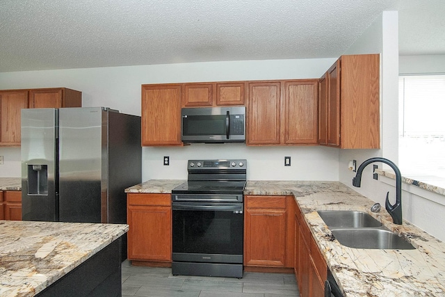 kitchen featuring appliances with stainless steel finishes, brown cabinets, and a sink