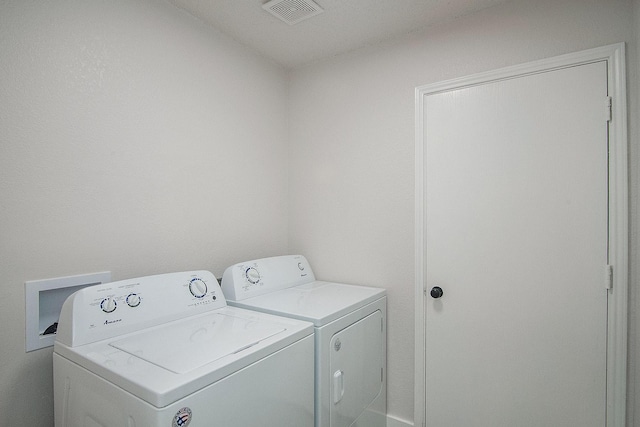 clothes washing area featuring washer and dryer, laundry area, and visible vents