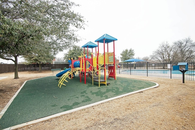 community jungle gym featuring fence and a community pool